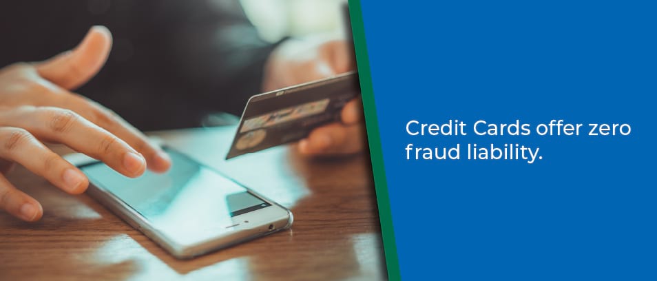 Credit Cards offer zero fraud liability - Image of a person holding their credit card and looking at a mobile phone